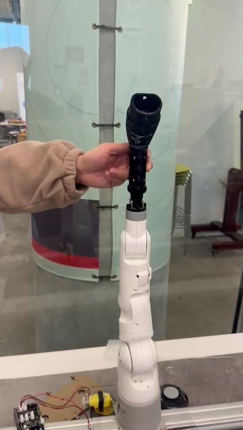 Video frame showing the larger-scale JuicyEV robotic arm and rail prototype during testing.